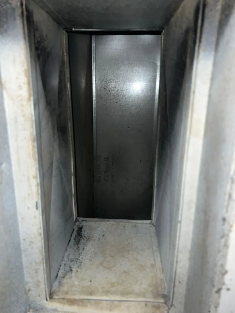 The same return duct cleaned back to bare galvanized metal, manufacturer stamp visible
