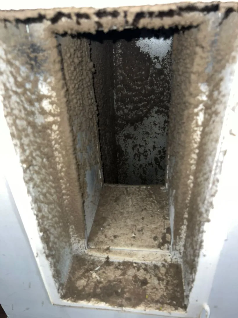 Inside a return duct coated in a thick layer of dust before cleaning